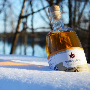 A bottle of 1000 Islands Moonshine placed on the snow